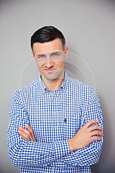 Upset young man standing with arms folded