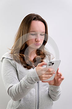 Upset young teen girl with mobile phone looking something, text