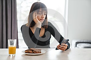 Upset young white woman looking at mobile phone