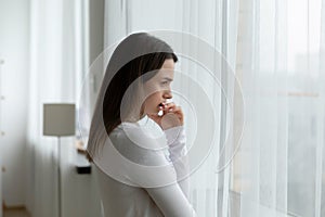 Upset young woman look in distance mourning or worrying photo