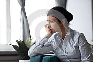 Upset young woman look in distance thinking
