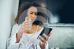 Upset young woman looking at the cellphone