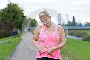 Upset young woman looking at her belly fat