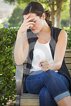 Upset Young Woman Sitting Alone on Bench