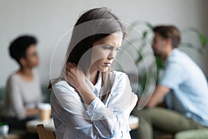 Upset young woman sitting alone in cafe offended at friends