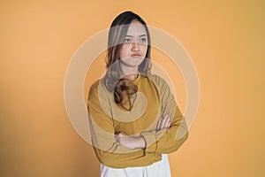 upset young woman stand with crossed hands on isolated background