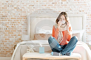 Upset young woman suffering from influenza at home photo