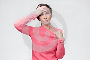 Upset young woman touching forehead feeling headache hurt.