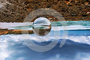 Upside-down shot of a crystal ball with the reflection of the sandy beach on a summer day