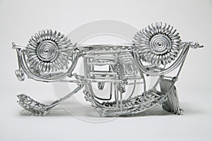 Upside down toy car made of pliable wire on white background