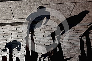 Upside down view of shadows of pedestrians projected on a pavement