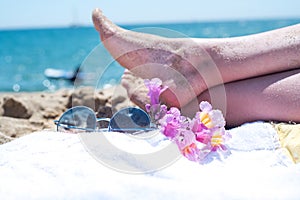 Upside woman feet and red pedicure wear pink sandals, sunglasses at seaside. Funny and happy fashion young woman relax on vacation