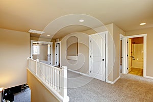 Upstairs hallway in big house with beige interior paint.