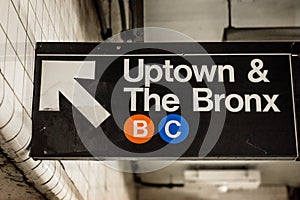 Uptown and The Bronx sign in a subway station in Manhattan, New York City photo