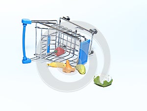 An upturned blue grocery cart with groceries. Isolated on a white background. The concept of sales and purchases