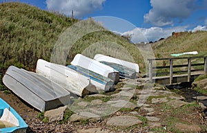 Upturned small rowing boats by a little bridge by the coast at Eype in Dorset