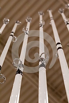 Upward-facing view of white fishing rods on display at a popular sporting goods retailer