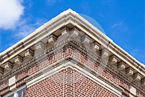 Upward view of a 19th Century red and white brick wall with cornice