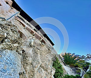 Upward View of the Cliffside Architecture of Santa Caterina del Sasso Hermitage Against a Clear Blue Sky photo