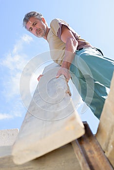 Upward view man holding plank wood