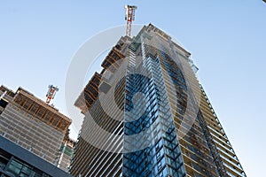 Upward view of modern skyscraper against blue sky