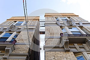 Upward view of space between two apartment buildings revealing metal catwalks between the buildings