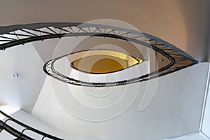 Upward view to oval narrow spiral staircase