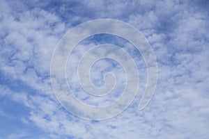 Upward view, wave of softy and white fluffy clouds under deep blue sky