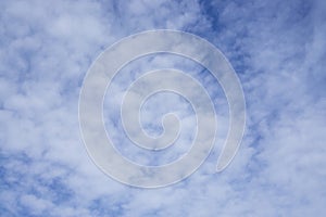 Upward view, wave of softy and white fluffy clouds under deep blue sky