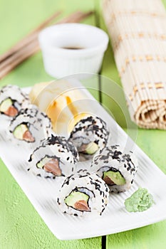 Uramaki sushi with avocado, raw salmon and black sesame