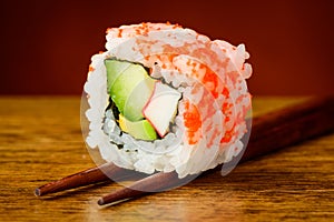 Uramaki sushi closeup on chopsticks photo