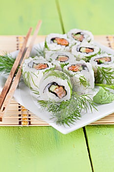 Uramaki sushi with cucumber, raw salmon and dill