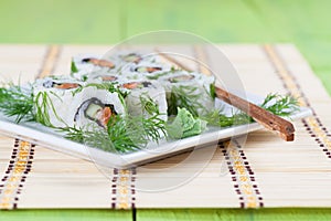 Uramaki sushi with cucumber, raw salmon and dill
