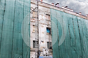 Urban apartment building covered with a green cloth during recon