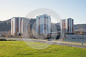 Urban area with residential buildings and the road against the background of a wooded mountain, in Krasnoyarsk in the autumn