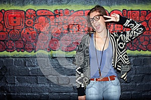 Urban art and style. Portrait of a trendy-looking young woman posing for the camera in front of a graffiti covered wall.