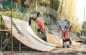 Urban athlete breakdancer performing somersault jump flip at skate park