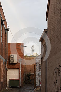 Urban Back Alley Way With Industrial Waste Bin And Mobile Phone Tower