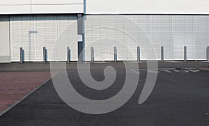 Urban background. An intersection of streets in front of a modern white building with a row of metal street poles.