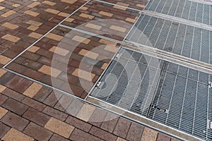 Urban background of sidewalk of mixed brick in red and yellow, inset steel grates