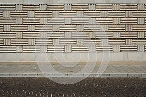 Urban background. Wall with geometric patterns, sidewalk and street with porphyry cubes
