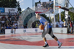 Urban basketball players playing basketball on sports court in Riga