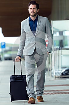 Urban business man with a suitcase walking outside in airport