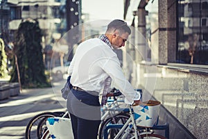 Urban businessman standing next to his bicycle