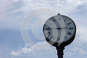 Urban clock on a background of a cloudy sky