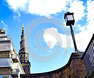 Urban composition highlighting in the background the black and golden spire of the Church of Our Saviour. Copenhagen, Denmark