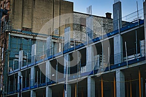 Urban construction site with scaffolding on a building exterior against a backdrop of older buildings, depicting city development