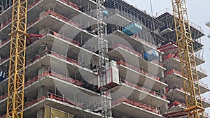 Urban Construction Site with Tower Crane, Close-up view of a multi-story building under construction with a tower crane