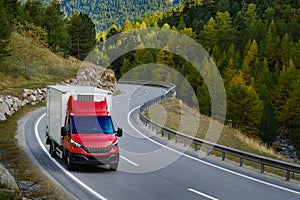 Urban delivery refrigerator box truck with red cabin driving on a twisty road.