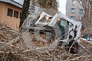 Urban emergency service removes a fallen tree on a road with special equipment traktor